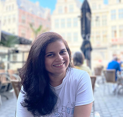 Madhura Parab of Optravation Energysitting at a cafe in city square in Ghent.