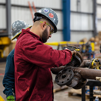 Optravation Energytrade and craft worker working on machinery.